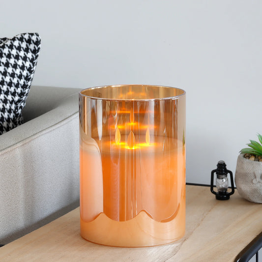 Gold glass flameless LED pillar candle on side table in modern living room, safe battery operated candle for home decor